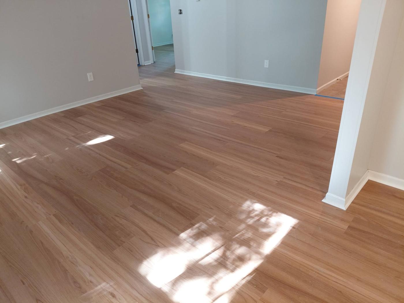 Plank flooring running through an open plan room in daylight